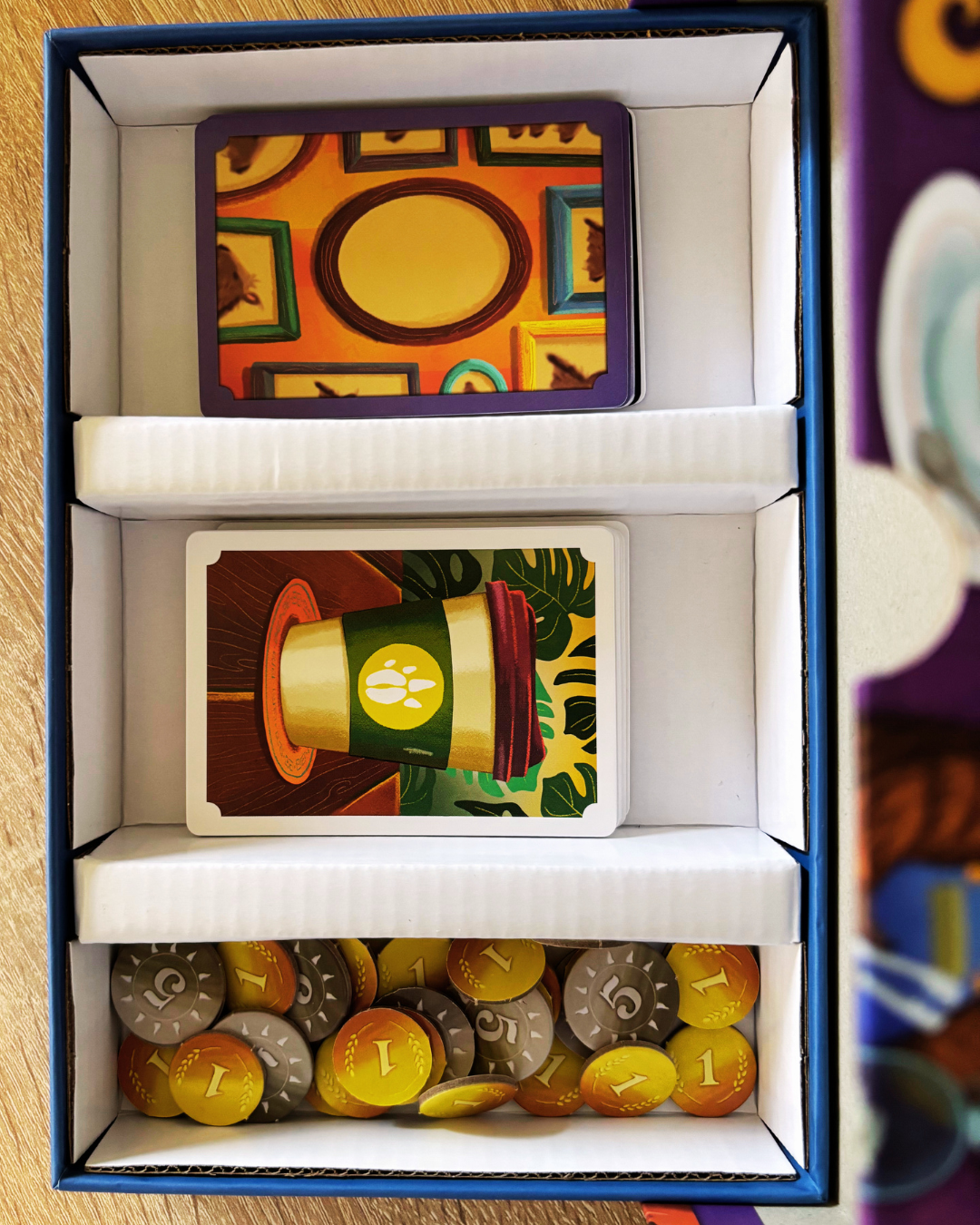 Eco-friendly cardboard insert organizing cards and tokens inside a board game box. Eco-friendly cardboard insert organizing cards and tokens inside a board game box.