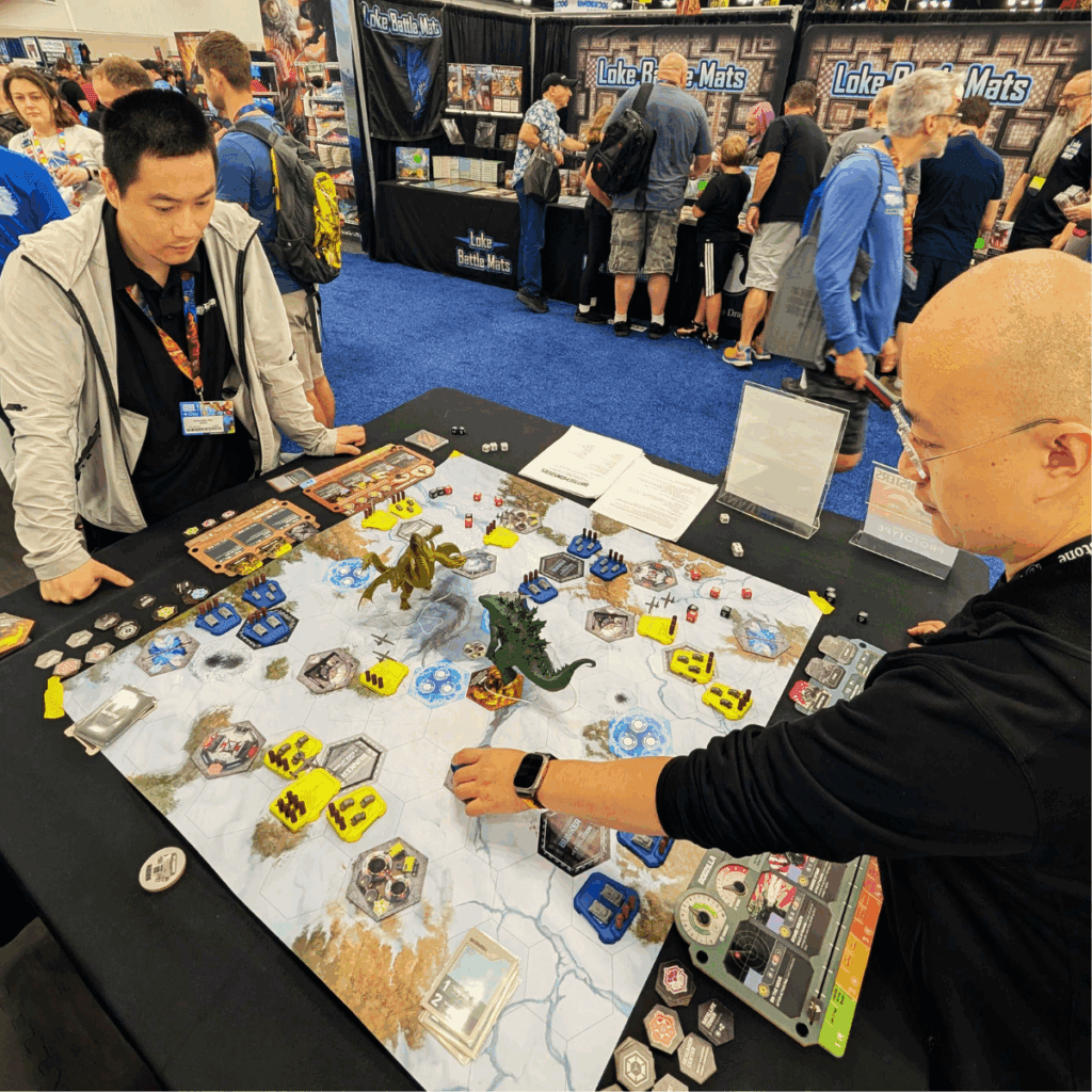 Two Rawstone team members testing a prototype board game at Gen Con 2025, exploring mechanics and quality of components for future manufacturing projects